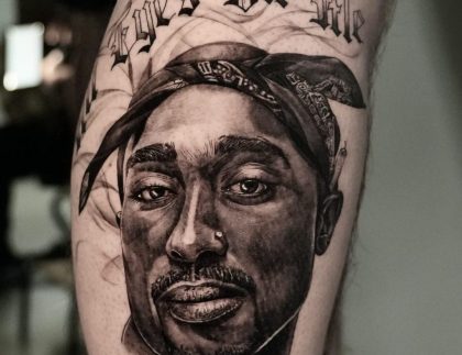 portrait tattoo of Tupac on the leg of a client with text above that reads "All Eyes on Me"